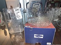 Nuutajarvi Flora glass bowl displayed on its original box and clear glass pitcher with handle, showing overall condition.