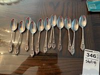 Top view of all 12 teaspoons laid out on wooden tabletop