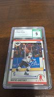 Front view of the graded 1990-91 Score Wayne Gretzky hockey card in protective casing with CSG grade 9 visible.