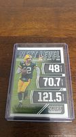 Close-up image of Aaron Rodgers Next Level Stats Score football card in protective plastic holder showing player stats.