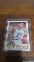 Front side of Kobe Bryant high school basketball card showing Kobe in his Lower Merion High School jersey, card artwork and text