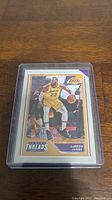 LeBron James 2020-21 Panini Threads basketball card in protective plastic sleeve on wooden surface.