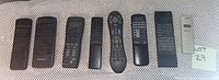 Photo showing 10 assorted remote controls laid out side by side on a flat surface. Various brands and models visible.