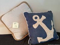 Both decorative pillows together: beige with braided jute trim and navy with applique anchor