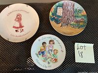 Front view of three plates showing detailed illustrations and text: Avon Mother's Day plate with children, Redwood Highway plate with tree and cabin, Holly Hobbie plate with girl in bonnet.