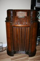 Front view of a vintage Philco console radio showing the full wooden cabinet, tuning dial, and control knobs.