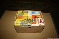 Photo of a cardboard box filled with multiple unopened boxes of vacuum tubes from various brands including Sylvania, CFR, and Tung-Sol