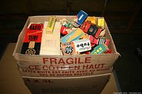 Cardboard box labeled "FRAGILE" filled with small branded boxes of vacuum tubes, view from above.