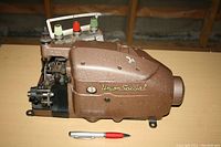 Side view of Union Special Style 39500 B sewing machine showing the machine's metal body, brand name, and thread spool holder with green and red spool tops.