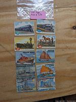 Photo showing all eight 1955 Topps Rails & Sails trading cards arranged in two columns on a wooden surface with a plastic bag and pink label showing the lot name.