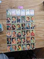 Photo showing 48 color trading cards featuring 1950s NBC TV and radio stars arranged on a wooden table.