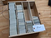 Photo of a wooden dealer box filled with numerous vintage Fleer baseball cards neatly organized in three compartments