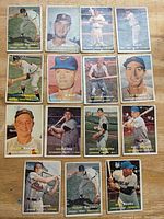 Overview photo showing 15 vintage 1957 Topps baseball cards arranged on a table. Cards feature different players including Ernie Banks, Rocco Colavito rookie card, and others.