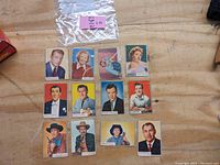 12 vintage 1953 Topps Who Z At Star celebrity trading cards laid out on a wooden surface, shows glossy front images with wear and moderate aging