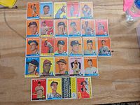 All 26 1958 Topps baseball cards laid out on a wooden surface showing the players and condition of the cards.
