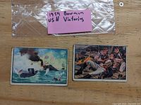 Two 1954 Bowman US Navy Victories trading cards in plastic bag, showing both cards with one naval ship scene on the left and sailors in distress on the right