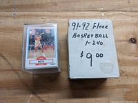 Photo of stacked 1991-1992 Fleer Basketball card set with box and separate display case holding one card (John Battle)