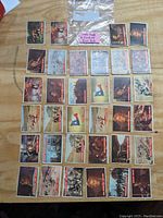 Top view of 34 Davy Crockett trading cards arranged on a wood surface, showing front artwork and labeling.