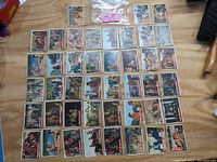 Photo showing 43 vintage Davy Crockett trading cards laid out on a wooden surface.