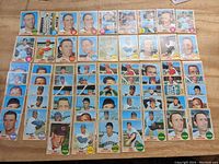 Full layout of 67 cards from 1968 Topps showing multiple rows of various players mostly in portrait poses on a wood table surface.