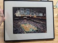 Full view of framed photo showing basketball game and arena interior with banners.
