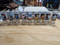 Full line-up of nine baseball collectible tumblers on wooden table showing all player images.