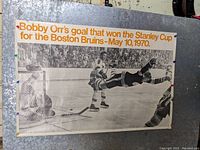 Wide photo of the black and white poster showing Bobby Orr scoring the goal with the title text at the top.