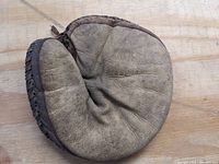 Top side of vintage leather catcher's mitt showing general wear and embossed brand name.