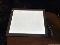 Photo of Cricut light pad illuminated with attached power cord