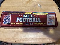 Image of the original red box with yellow and white text reading '1991 Collector Set Score NFL Football 690 Player Cards The Complete Set Series 1 and 2' with player images on the sides.