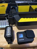 GoPro camera with lens cap and Knog LED light in front of closed hard plastic case