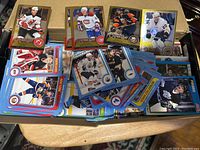 Photo showing a pile of assorted hockey cards featuring various players and teams.