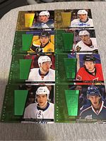Front view of eight NHL hockey cards with different player images, patches, and autographs.