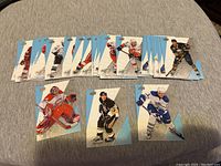 Photo of a set of 18 hockey cards with players in action in various team uniforms.