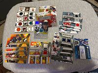 Photo of hockey card collection including multiple memorabilia and autograph cards with various colored patches, laid out on a grey surface.