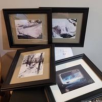 Four black framed black and white photographic prints laid out, showing varying mat hues and natural winter scenes