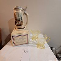 Avon Shipbuilder Beer Stein displayed on original box next to vintage yellow glass cream and sugar set on table.