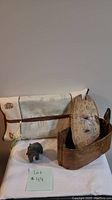 Photo showing all items: Japanese Kleenex box, stone elephant figurine, wooden carved boat with oval mask inside.