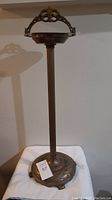 Full view of vintage bronze metal ashtray stand showing overall height and design.