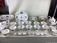 Front view of full Hammersley fine china set with tea cups, saucers, dessert plates and serving pieces