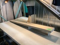 Wall mounted entry shelf showing full length with half oval mirror and open cubby underneath supported by metal bracket