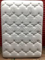 Full front view of mattress upright against red background