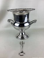 Silverplated ice bucket showing shape, handles, and pedestal base