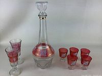 Full set showing tall decanter with stopper, 2 wine glasses, and 5 shot glasses collectively on white background