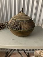 Side view of the vintage brass shade showing the vertical slits and patina on the metal