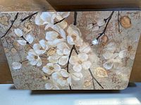 Photo of one bristol board placemat showing detailed floral design with white flowers and gold accents.