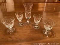 Photo of five assorted crystal glasses with various cuts and shapes in excellent condition.