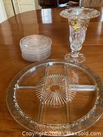 Dessert plates stacked with hors d'oeuvres platter and tall vase visible on wooden table