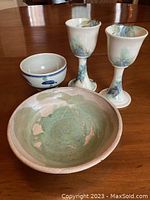 Four items: two goblets, one salad bowl, and one larger soup bowl arranged on wood table