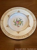 Top view of a Minton china soup bowl showing floral center and gold decorated rim
